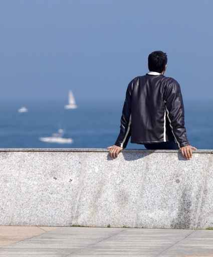 Joven sentado frente al mar